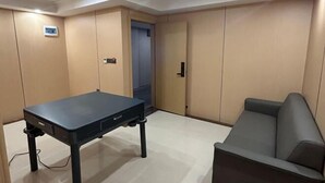 A room with a table, a sofa, and a door. - Ganzhou Yuekelong Holiday Hotel (Ganzhou)
