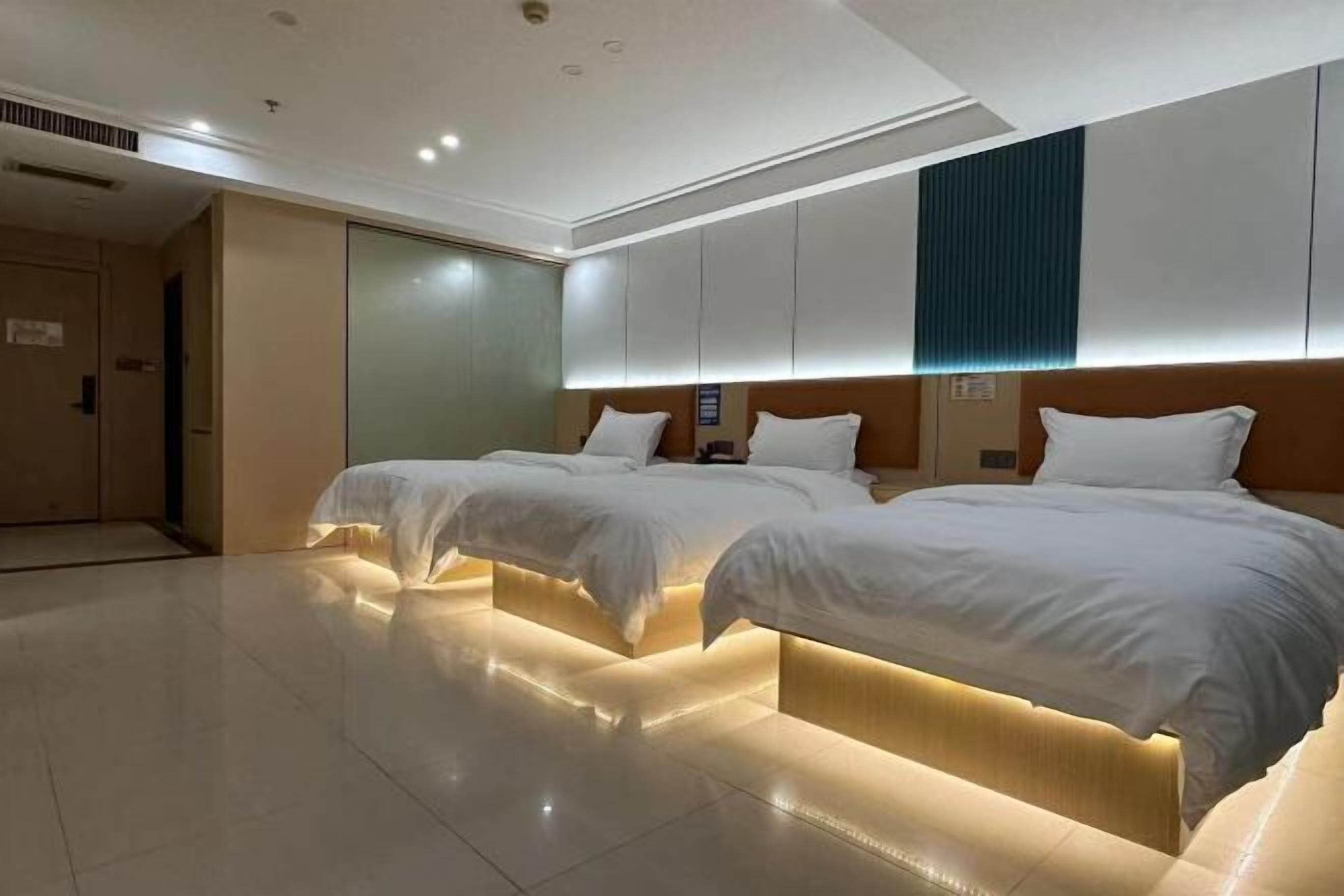 A hotel room with two beds, a large mirror, and a modern design.