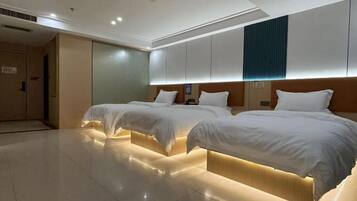 A hotel room with two beds, a large mirror, and a modern design.