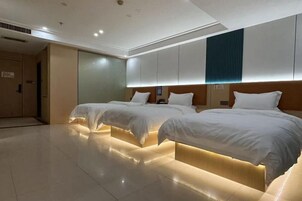 Habitación de hotel con dos camas, un espejo grande y un diseño moderno.