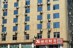A multi-story building with numerous windows and air conditioning units. - Ganzhou Yuekelong Holiday Hotel (Ganzhou)