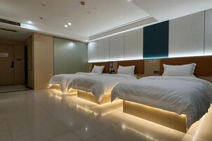 Habitación de hotel con dos camas, un espejo grande y un diseño moderno.