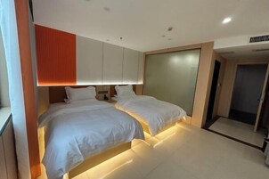 Una habitación de hotel moderna con dos camas, un ventanal grande y una puerta corrediza.