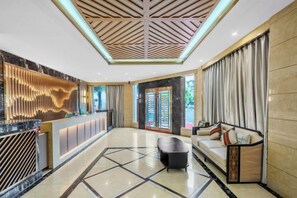 A hotel lobby with a reception desk, seating area, and a geometric floor pattern. - Aifeite Hostel (Chengdu)