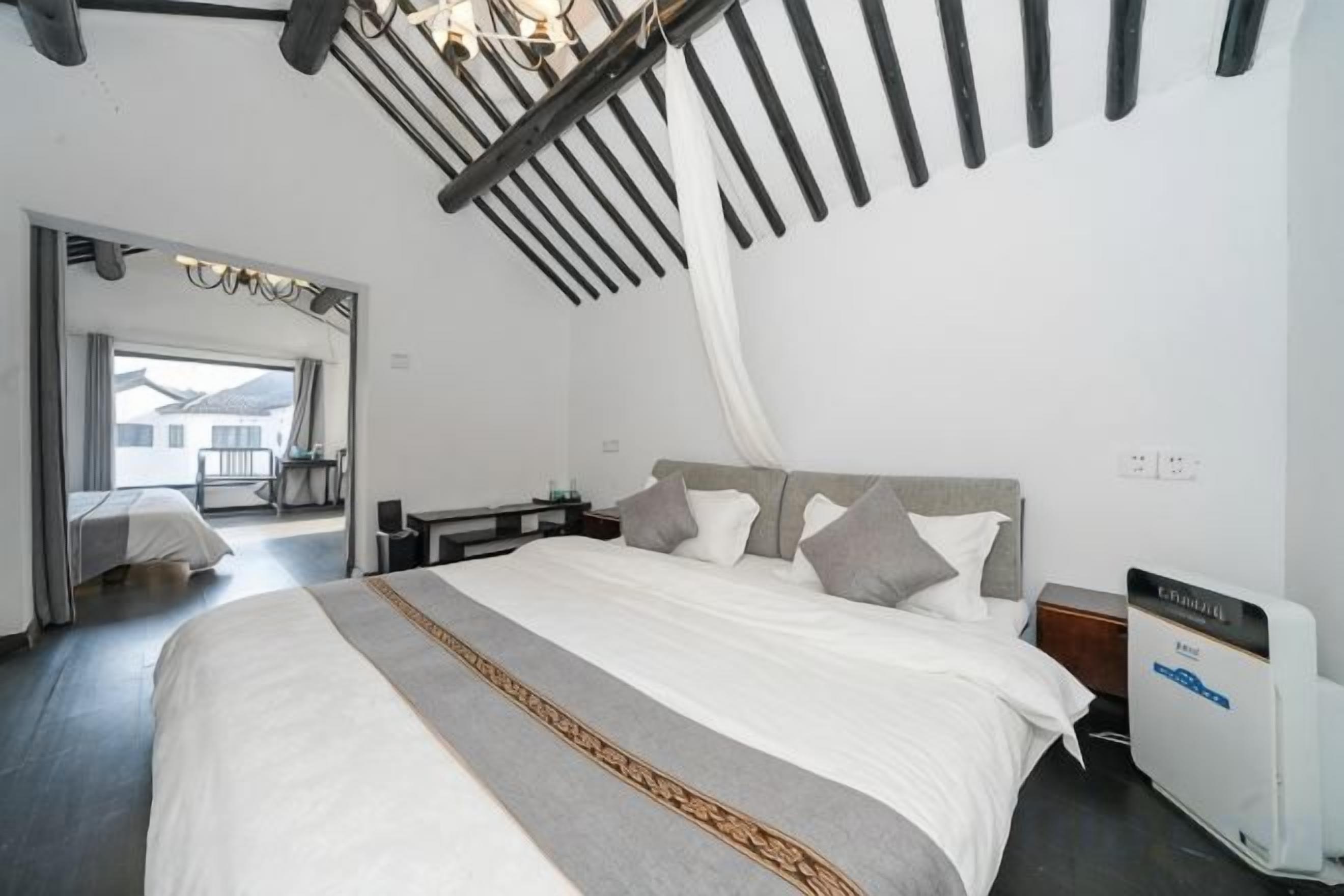 Ein Schlafzimmer mit einem großen Bett, einem Nachttisch und einem Deckenventilator.