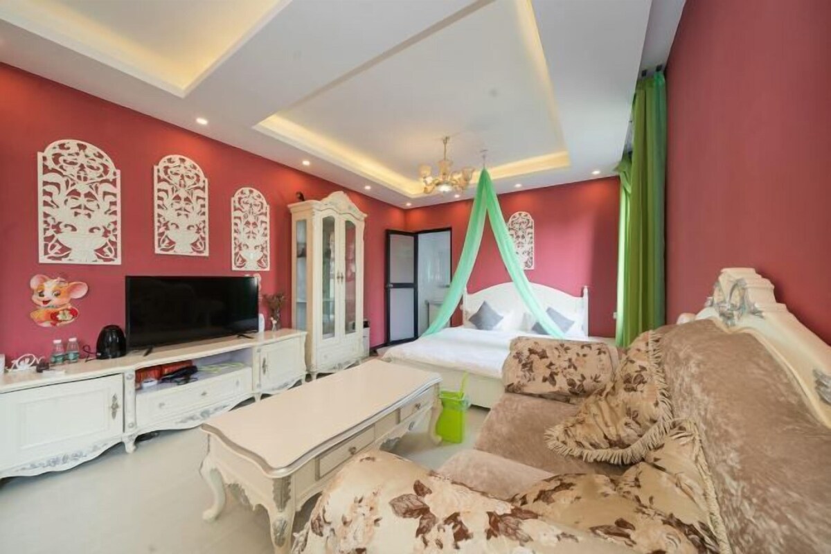 A bedroom with a bed, a television, a dresser, and a nightstand.