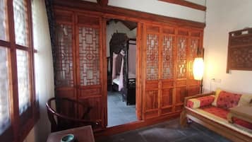 Una habitación tradicional con puerta corredera de madera, un sofá, una mesa con un cuenco y una lámpara.