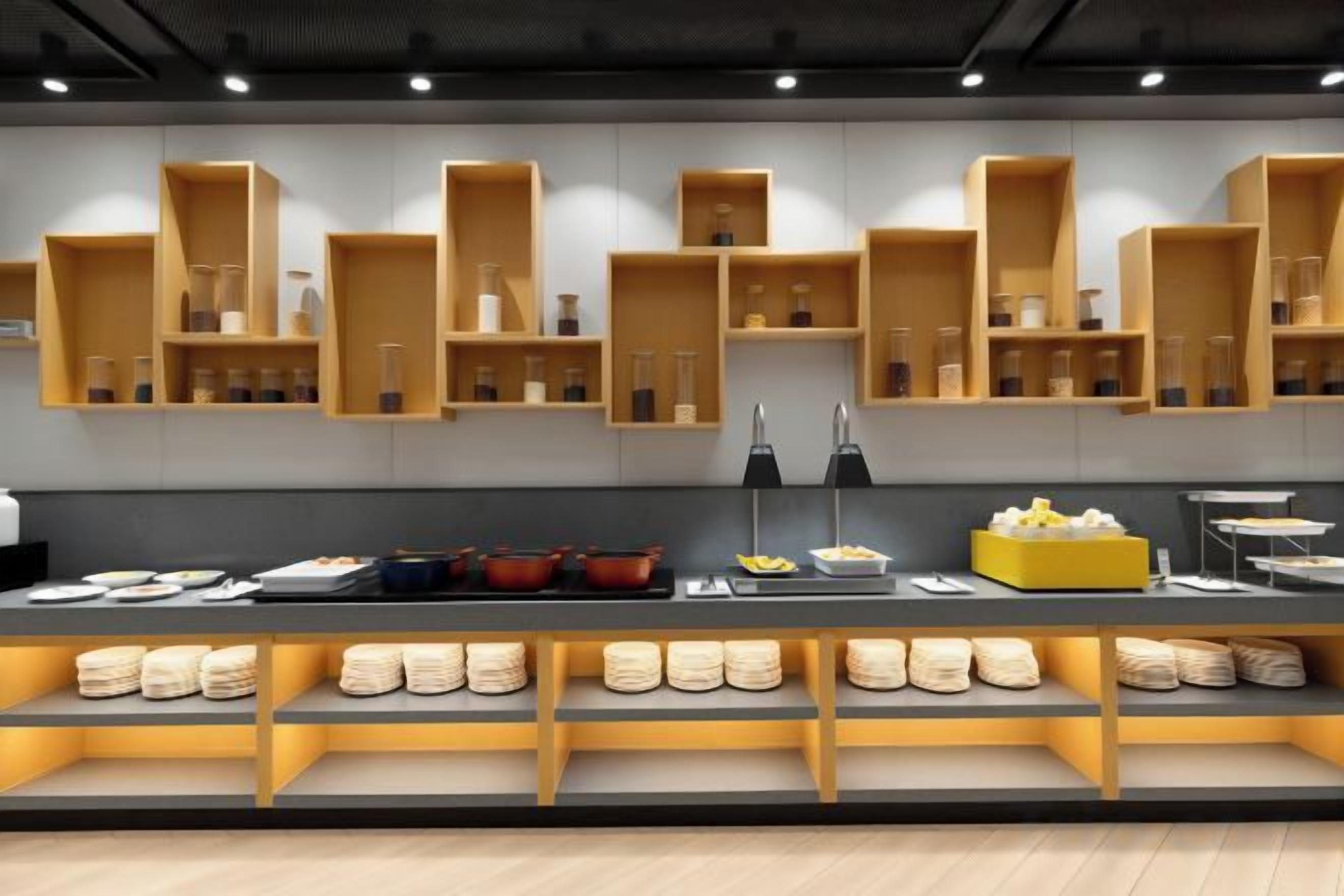 A modern kitchen with wooden shelves and a buffet setup.