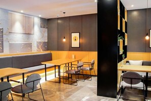 Een modern interieur met een zithoek, tafels en stoelen.