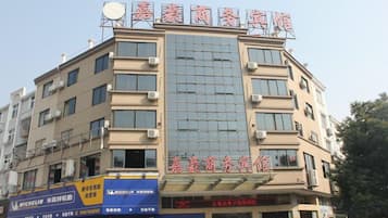 A multi-story building with signage for a hotel and a business center.
