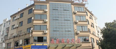 A multi-story building with signage for a hotel and a business center.