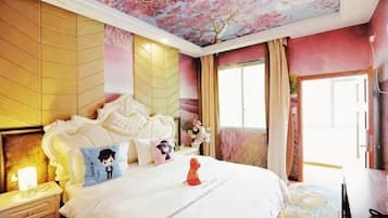 A bedroom with a large bed, a nightstand, a dresser, and a ceiling with a floral design.