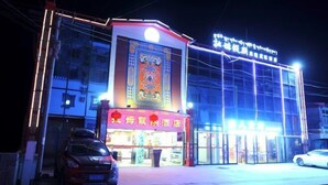 A hotel with a traditional design, featuring a prominent entrance and signage. - Rahm Holiday Theme Hotel (Xiaojin)