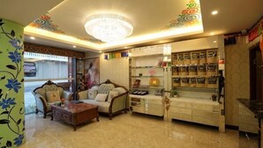 A hotel lobby with a chandelier, sofas, a coffee station, and a patterned wall. - Rahm Holiday Theme Hotel (Xiaojin)