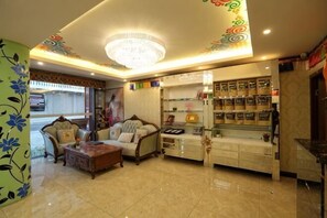 A hotel lobby with a chandelier, sofas, a coffee station, and a patterned wall. - Rahm Holiday Theme Hotel (Xiaojin)