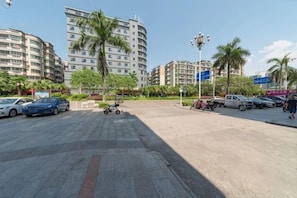 A parking lot with multiple cars, a stroller, and a pedestrian crossing. - Yongcheng Business Hotel (Qingyuan)