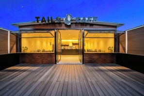 A building with a sign reading 'TAILS OF SAFFRON' and a wooden deck in front.