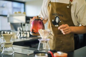 A person in a cafe apron pouring a drink into a glass. - Zhengzhou Ruolan Hotel (Zhengzhou Railway Station Yinji Plaza) (Zhengzhou)