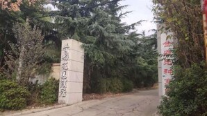 A gated entrance with a sign indicating a hotel. - AA Hotel Chain Lianyungang Jinxu Garden Branch (Lianyungang)