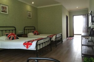 A room with two beds, a desk, and a chair.