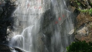 A waterfall cascading over rocky terrain. - AA Hotel Chain Lianyungang Jinxu Garden Branch (Lianyungang)