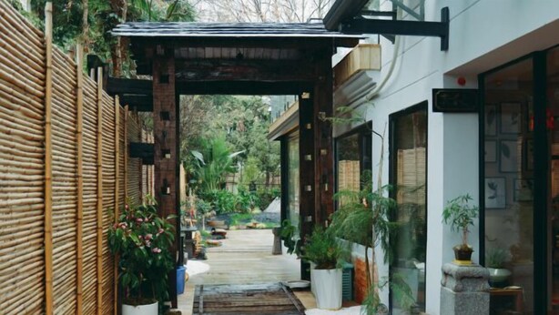 A narrow pathway leading to a traditional Japanese-style building with a wooden walkway, bamboo fencing, and potted plants. - Yunqi Chinese Inn (Kunming Dianchi Haigeng Dam) (Kunming)