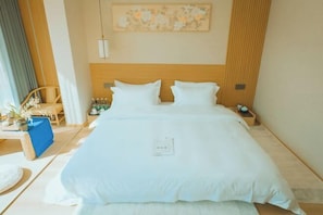 A neatly made bed with white linens, a wooden headboard, and a small bedside table with a lamp.