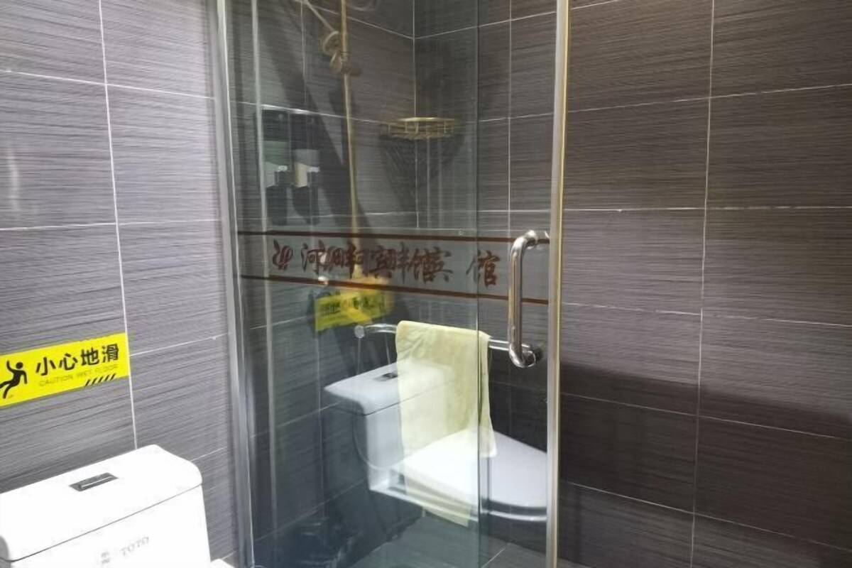 Cabina de ducha con mampara de vidrio que incluye un inodoro.