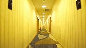 A hotel hallway with a patterned carpet, doors on both sides, and overhead lighting. - Kaiyue Hotel (Wuhan Vanke Emerald Binjiang) (Wuhan)
