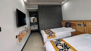 Een hotelkamer met twee bedden, een televisie, een houten hoofdbord en een muur met een baksteenmotief.