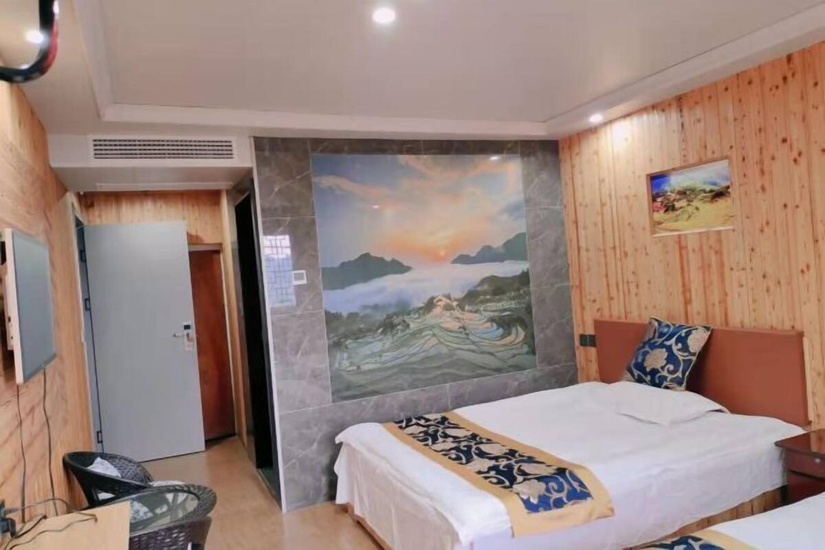 Ein Hotelzimmer mit Bett, Sessel, einem Bild an der Wand und einer Holzpaneelverkleidung.