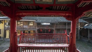 Een traditioneel Chinees paviljoen met een rode balustrade en een balkon.