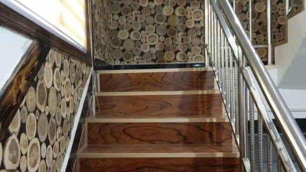 A staircase with wooden steps and a wall of stacked logs. - Anyu · Wooden House (Zaozhuang)
