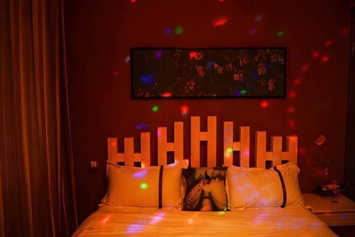 A bed with a headboard, pillows, and a blanket.