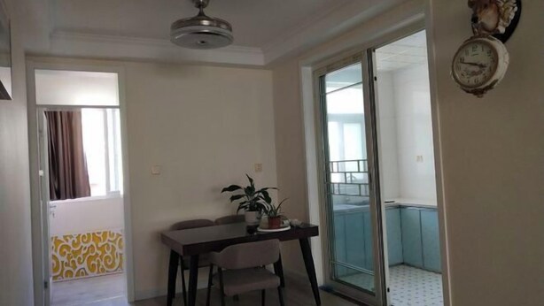 A dining area with a table and chairs, a ceiling fan, and a sliding glass door leading to a balcony. - Anyu · Wooden House (Zaozhuang)