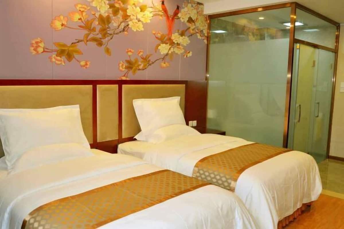 Habitación de hotel con dos camas, un espejo grande y una puerta corredera.
