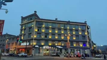 A multi-story hotel with a traditional architectural style, featuring a ground floor with commercial spaces and upper floors with rooms.