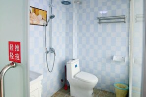 A bathroom with a toilet, shower, and a red sign on the wall. - Phoenix Bohan Inn (Fenghuang County)