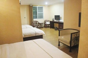 A hotel room with a bed, two chairs, a desk, and a television. - Xishui Songxuan Clubhouse Inn (Xishui)