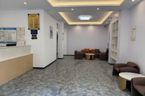 A reception area with a counter, seating, and informational posters on the walls. - Xishui Songxuan Clubhouse Inn (Xishui)
