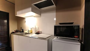 A compact kitchen with a microwave, a sink, and a small refrigerator. - Brian Machiya Inn (Kyoto)