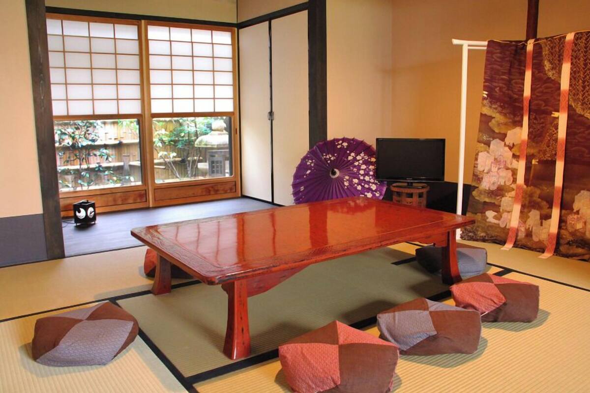 A traditional Japanese room with tatami flooring, a low wooden table, and sliding shoji doors.