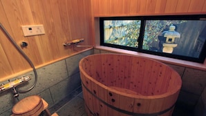 A wooden bathtub with a window, a wooden toilet, and a towel rack. - Brian Machiya Inn (Kyoto)