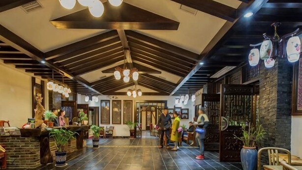 A spacious lobby with a high ceiling, chandeliers, and potted plants. - Biancheng Gushi Theme Culture Hotel (Yongshun)