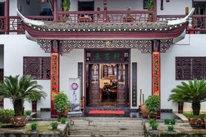 Un edificio tradicional chino con techo de tejas rojas y puertas de madera ornamentadas.