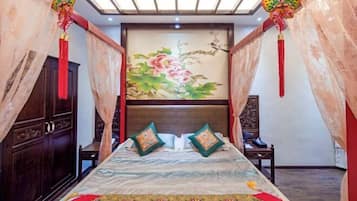 Un dormitorio con cama, cortinas, un cuadro y un armario de madera.