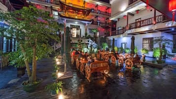 Un patio con muebles de madera tradicionales y plantas en macetas.