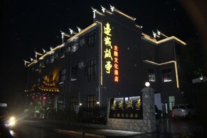 Un edifici amb cartelleria il·luminada i una base de pedra, probablement un hotel o un centre cultural.