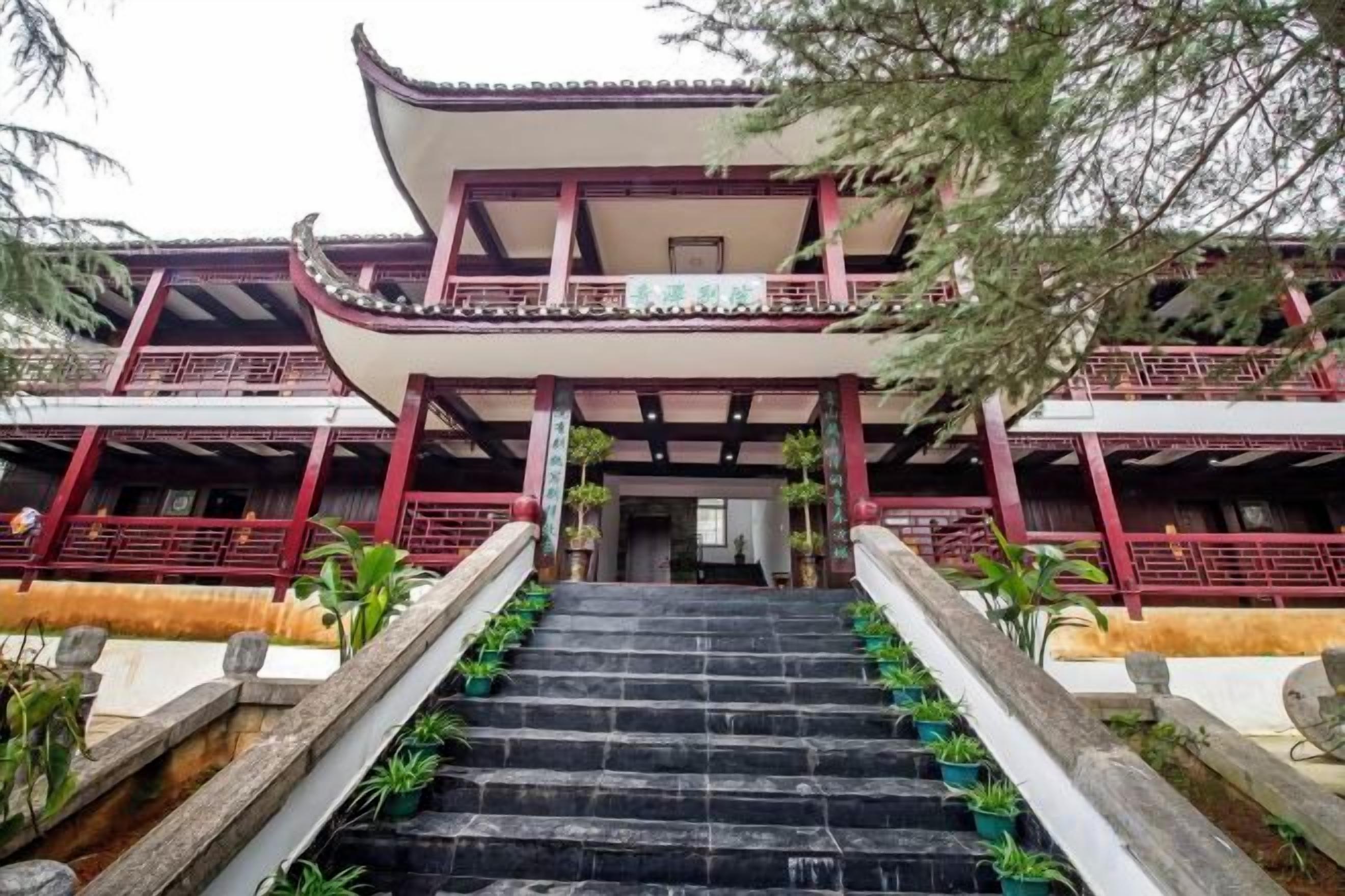 Un edificio tradicional de varios pisos con una escalera que conduce a la entrada.