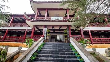 Un edificio tradicional de varios pisos con una escalera que conduce a la entrada.